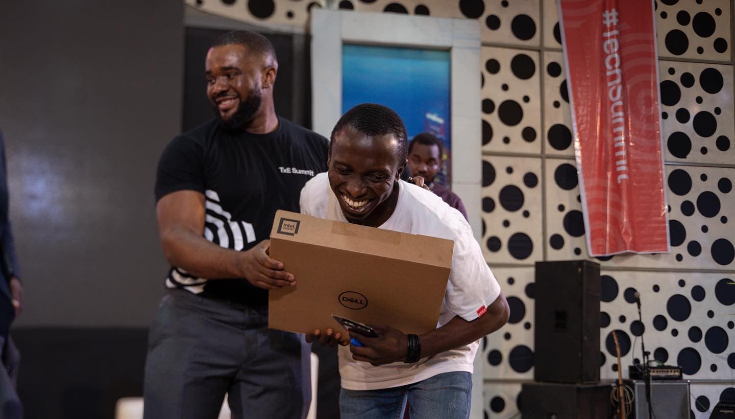 A young attendee receives a laptop